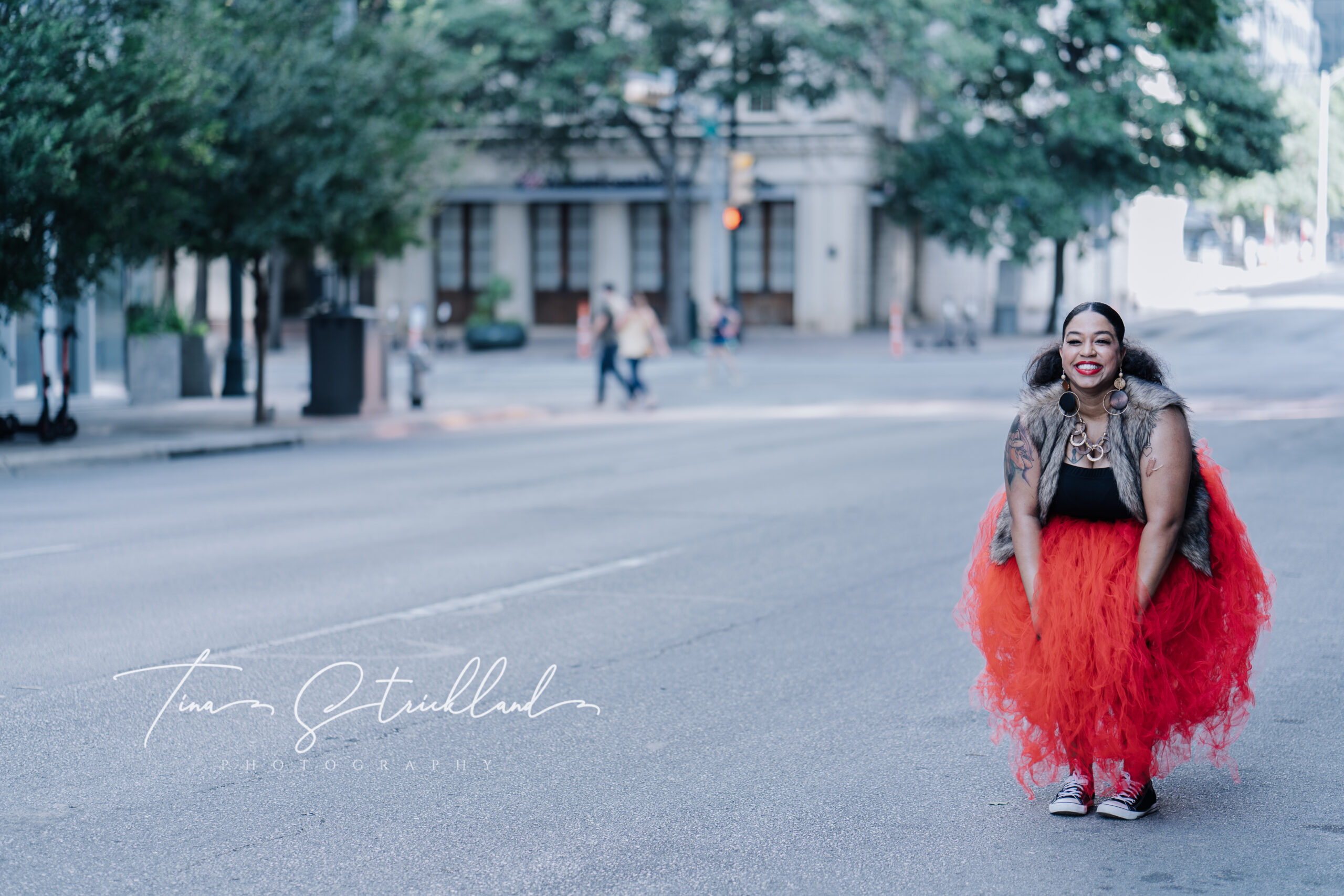 Full-figured woman wearing a red tutu, and standing in the street
